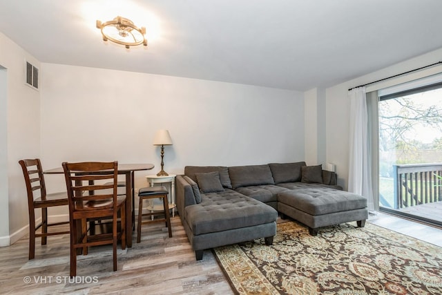 living area featuring visible vents, baseboards, and wood finished floors