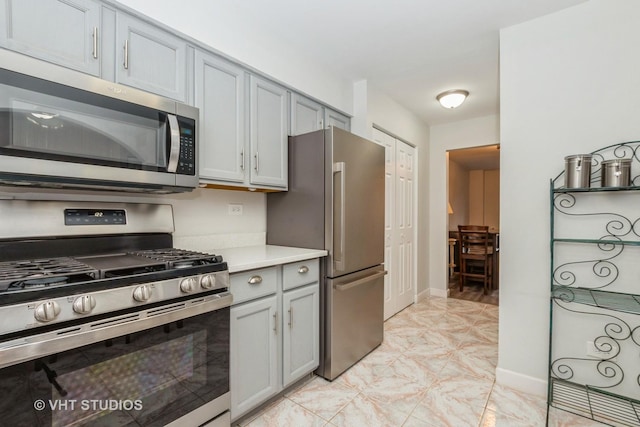 kitchen with gray cabinets, appliances with stainless steel finishes, light countertops, and baseboards