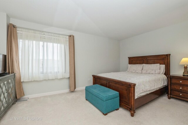 bedroom featuring light colored carpet and baseboards