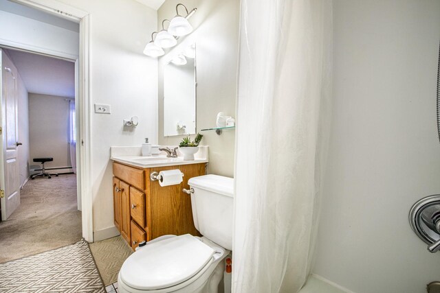 bathroom featuring vanity, toilet, baseboards, and a baseboard heating unit