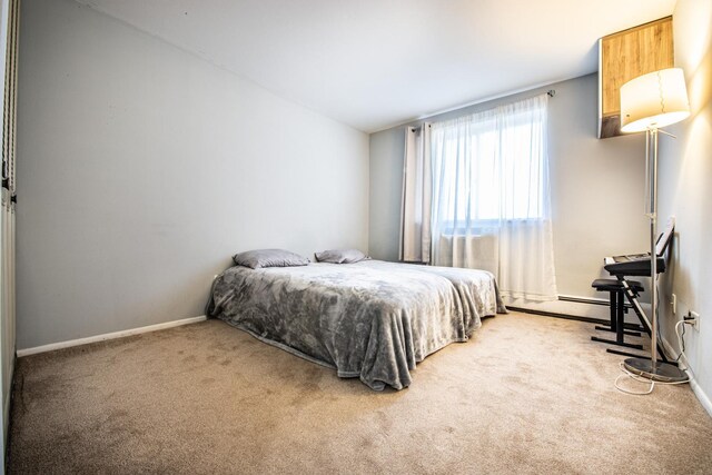 bedroom featuring lofted ceiling, carpet, baseboards, and a baseboard radiator