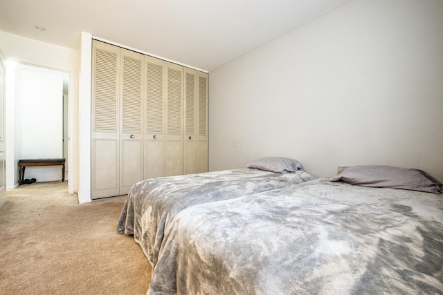 bedroom featuring a closet and light colored carpet