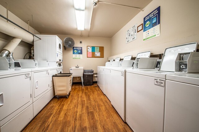 shared laundry area with a sink, light wood-type flooring, stacked washer and dryer, and washing machine and dryer