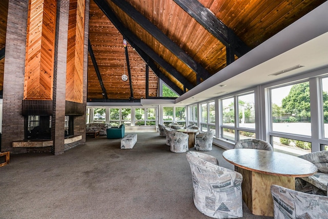 unfurnished sunroom with visible vents, wooden ceiling, a fireplace, and lofted ceiling with beams