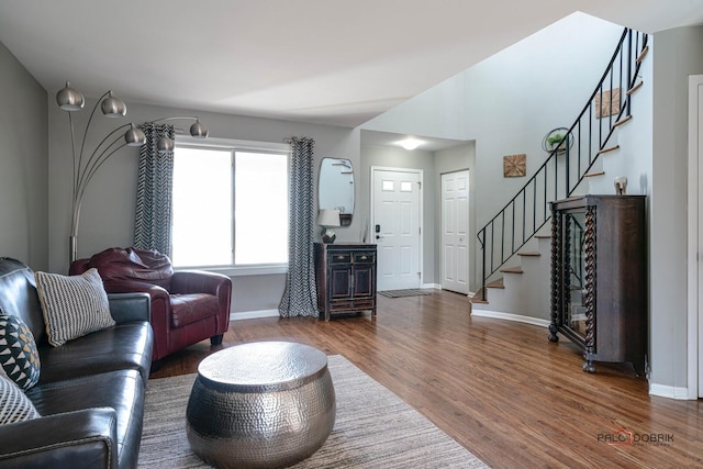 living area featuring stairway, baseboards, and wood finished floors