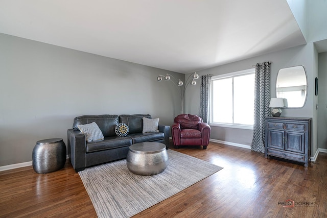 living area with dark wood-type flooring and baseboards