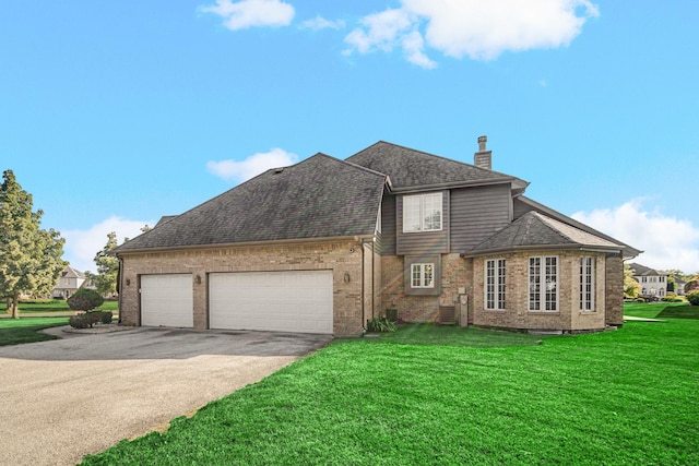 view of front facade with a front lawn, aphalt driveway, roof with shingles, a chimney, and a garage