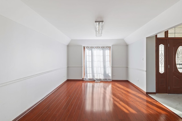 entryway with hardwood / wood-style floors, lofted ceiling, and baseboards