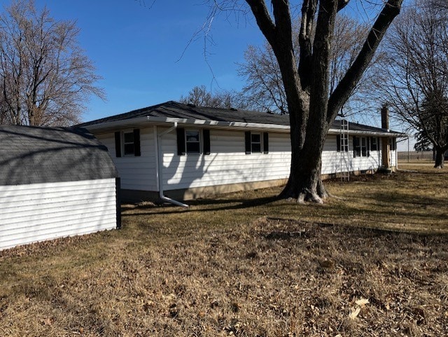 view of home's exterior featuring an outbuilding, a storage shed, and a lawn