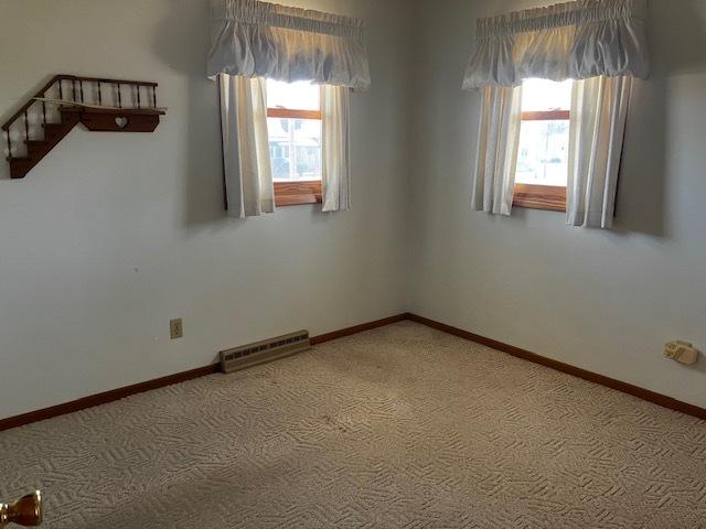 unfurnished room with visible vents, light colored carpet, baseboards, and a healthy amount of sunlight