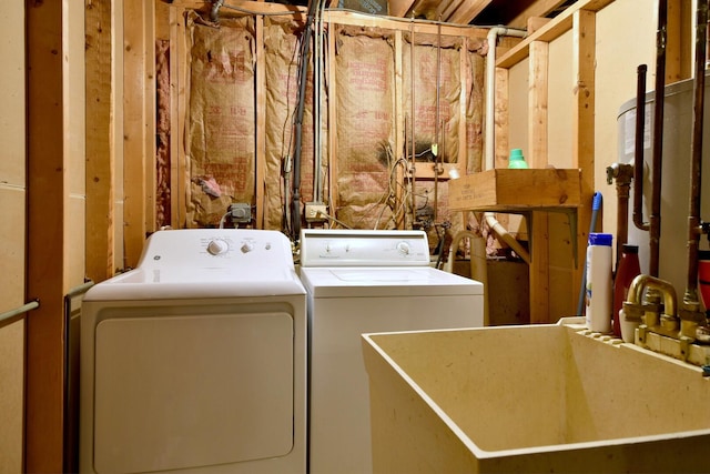 clothes washing area with laundry area, separate washer and dryer, and a sink