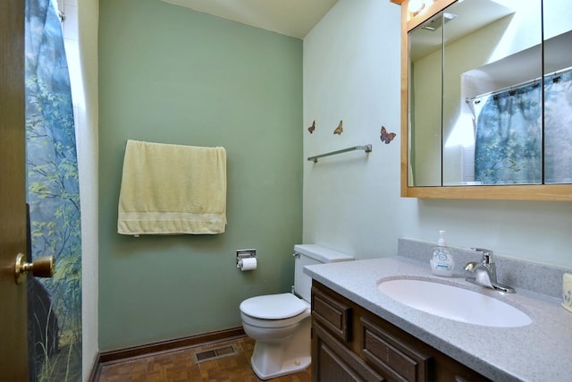 bathroom featuring vanity, a shower with shower curtain, baseboards, visible vents, and toilet