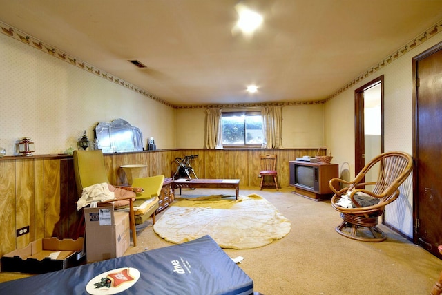 living area featuring visible vents, carpet, wainscoting, and wallpapered walls