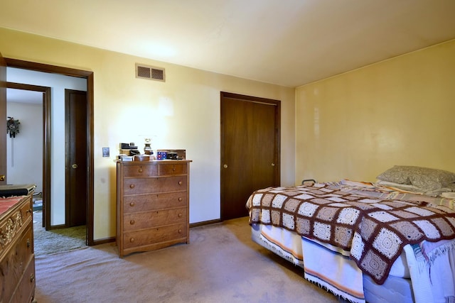 carpeted bedroom featuring visible vents, baseboards, and a closet