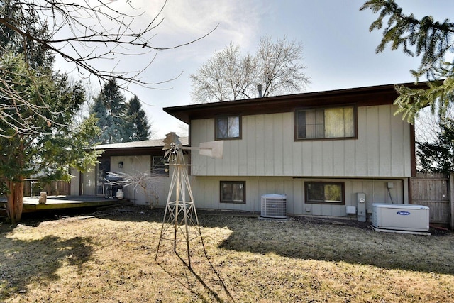 rear view of property with central air condition unit, a wooden deck, and fence