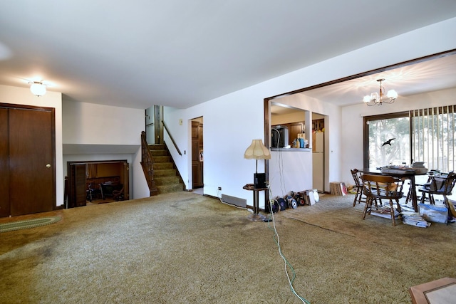 carpeted living room with a notable chandelier and stairs