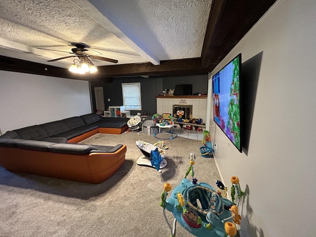 living area featuring ceiling fan, beamed ceiling, carpet flooring, a fireplace, and a textured ceiling