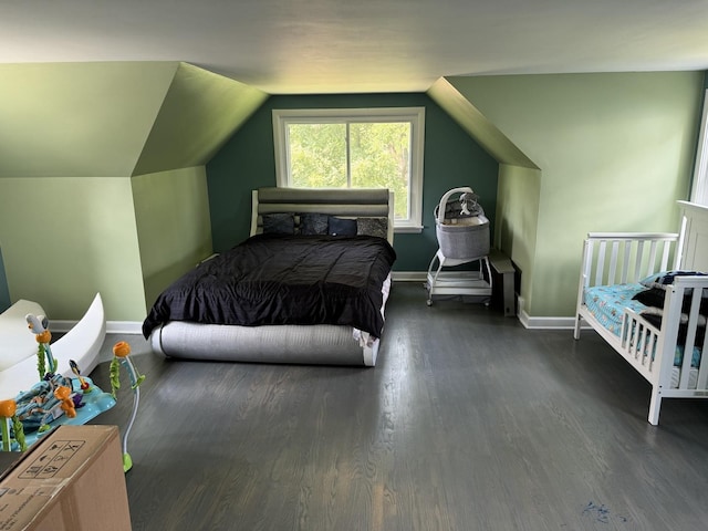 bedroom with dark wood finished floors, baseboards, and vaulted ceiling