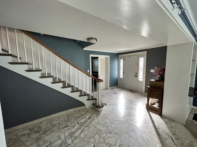 entryway featuring stairway, marble finish floor, and ornamental molding