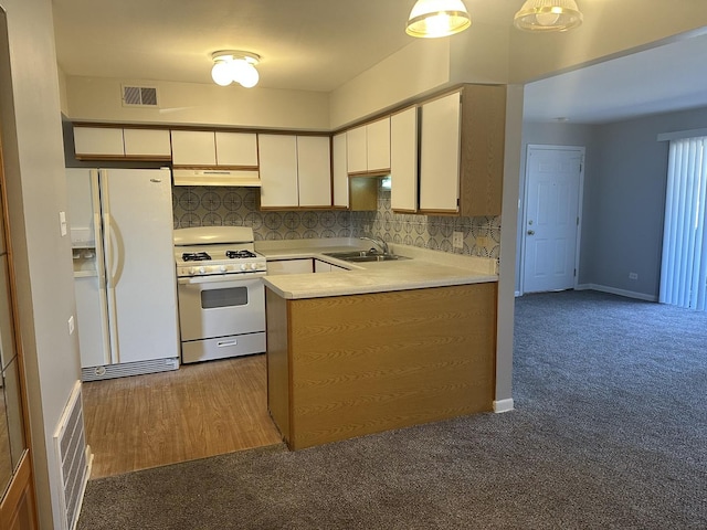 kitchen featuring white appliances, visible vents, a sink, light countertops, and under cabinet range hood