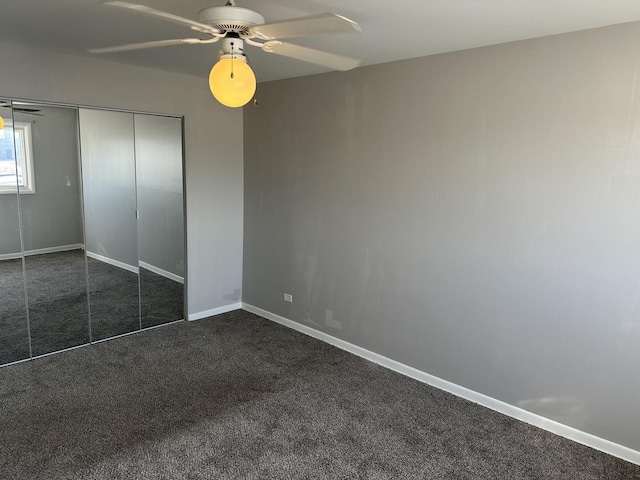 unfurnished bedroom with a closet, baseboards, a ceiling fan, and dark carpet