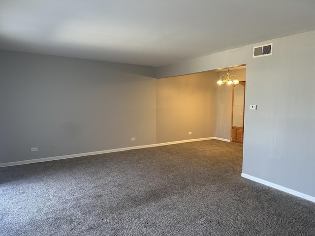 unfurnished room featuring baseboards, visible vents, dark colored carpet, and a chandelier