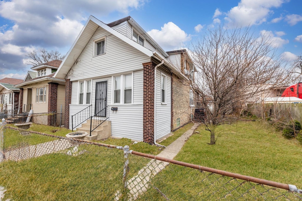 bungalow-style house featuring entry steps, a front yard, fence, and brick siding