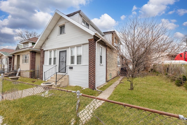 bungalow-style house featuring entry steps, a front yard, fence, and brick siding