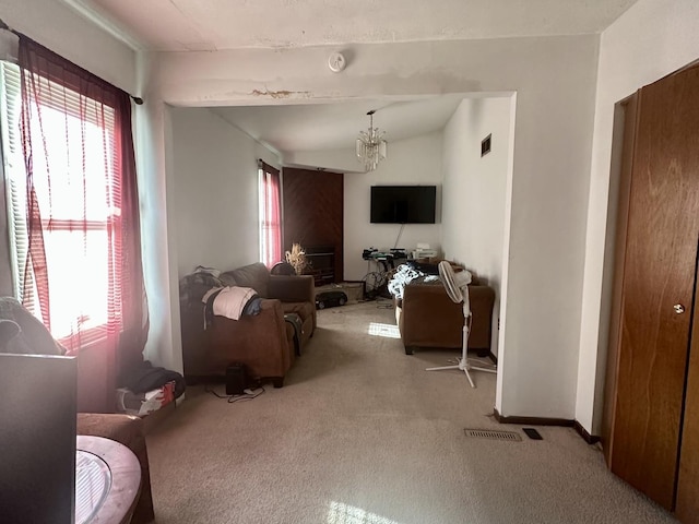 living area with a chandelier, visible vents, lofted ceiling, and carpet floors