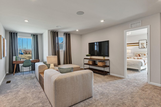 carpeted living area with visible vents, recessed lighting, and baseboards