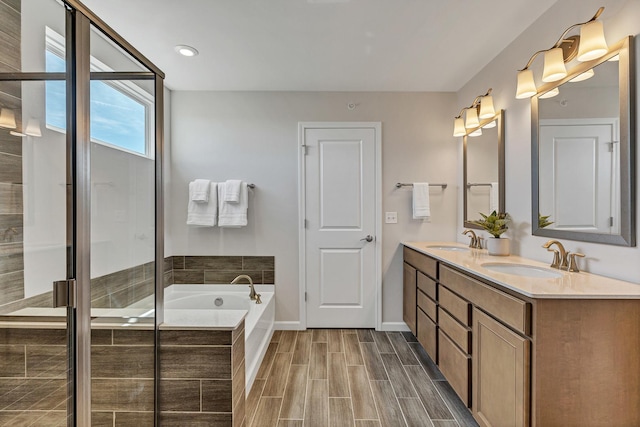 bathroom featuring a garden tub, wood tiled floor, a stall shower, and a sink