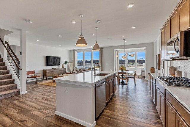 kitchen featuring dark wood-type flooring, open floor plan, recessed lighting, stainless steel appliances, and a sink