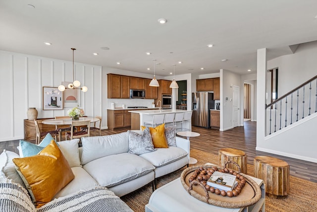 living room with recessed lighting, baseboards, dark wood-style floors, and stairs