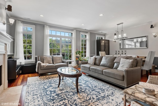 living room featuring light wood finished floors, recessed lighting, an inviting chandelier, and ornamental molding