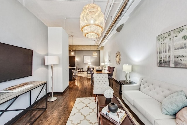 living room with dark wood-type flooring and baseboards