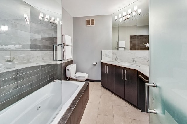 bathroom with tile patterned flooring, a jetted tub, toilet, and a sink