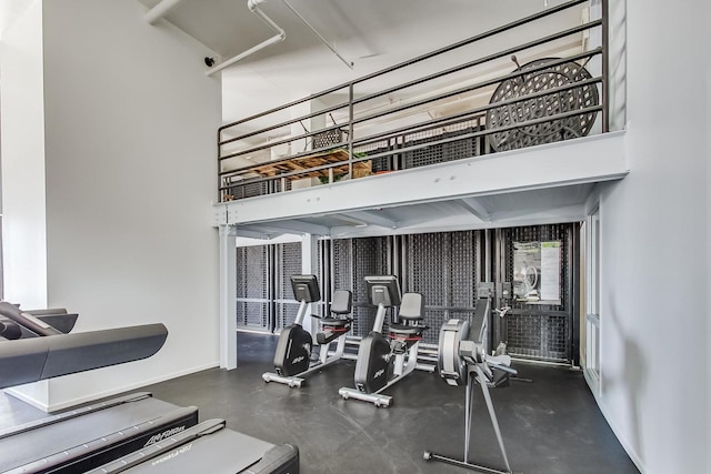 gym with a high ceiling and baseboards