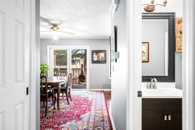 dining room with baseboards, a textured ceiling, and a ceiling fan