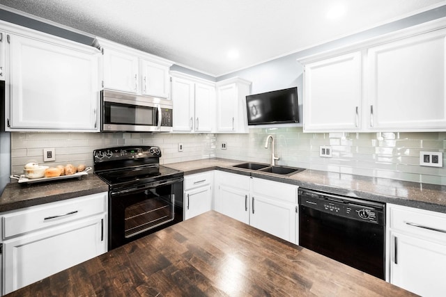 kitchen featuring dark countertops, black appliances, decorative backsplash, white cabinetry, and a sink