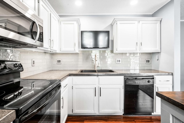 kitchen with a sink, decorative backsplash, black appliances, and white cabinetry