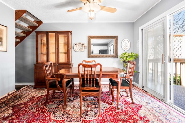 dining space featuring a ceiling fan, light wood-type flooring, and baseboards