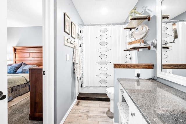 bathroom featuring vanity, a shower with curtain, wood finished floors, baseboards, and toilet