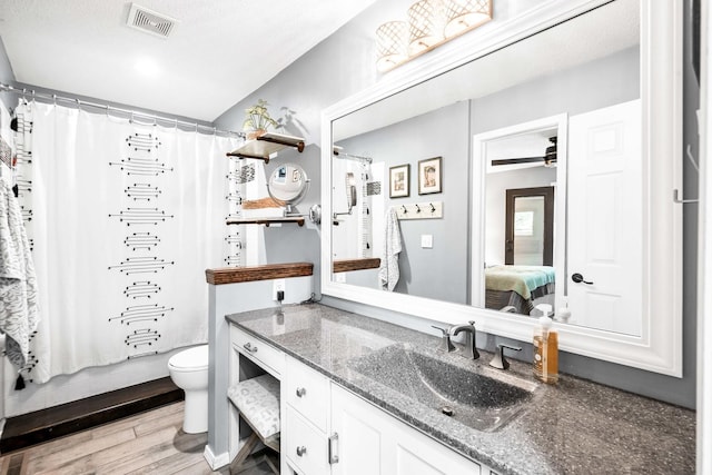 ensuite bathroom with visible vents, toilet, ensuite bathroom, wood finished floors, and vanity