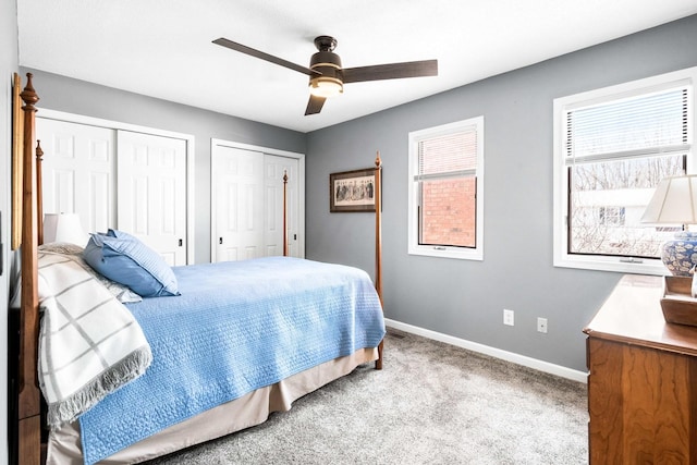 bedroom featuring baseboards, two closets, carpet, and a ceiling fan