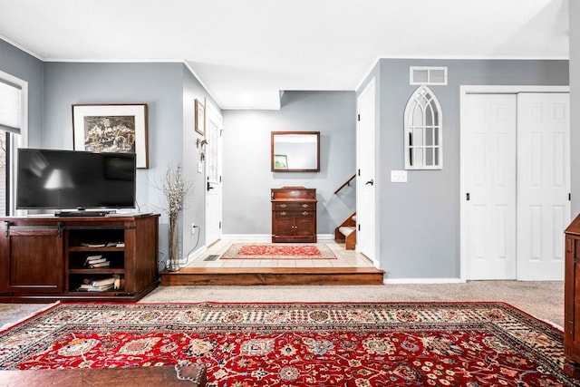 foyer with stairs, crown molding, baseboards, and visible vents