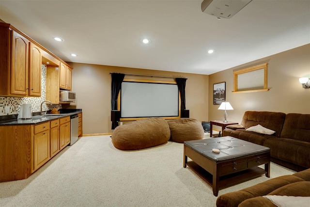 home theater with recessed lighting, baseboards, light colored carpet, and a sink