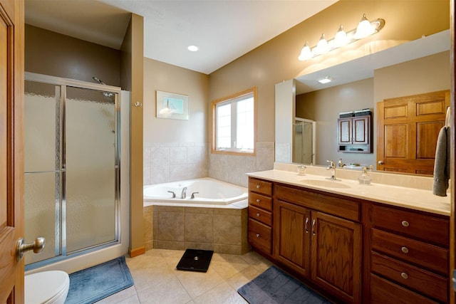 full bathroom featuring tile patterned floors, a garden tub, toilet, a stall shower, and vanity