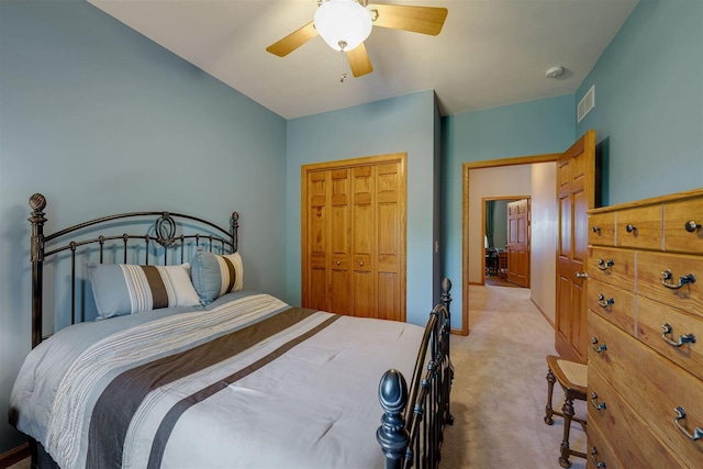 bedroom with visible vents, baseboards, light colored carpet, a closet, and a ceiling fan