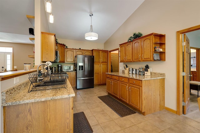 kitchen featuring stainless steel appliances, brown cabinets, light tile patterned flooring, and hanging light fixtures