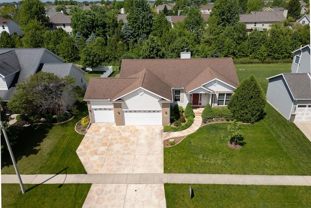 view of front of property featuring a front yard, an attached garage, driveway, and a chimney